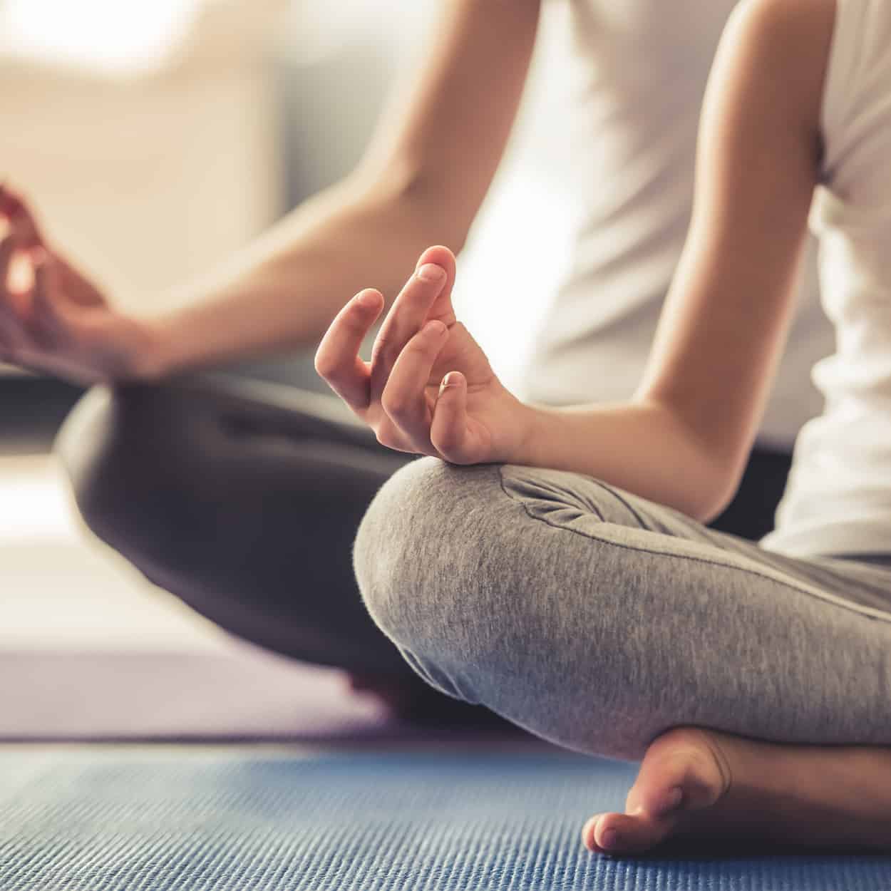 two people practicing yoga during at-home addiction rehab