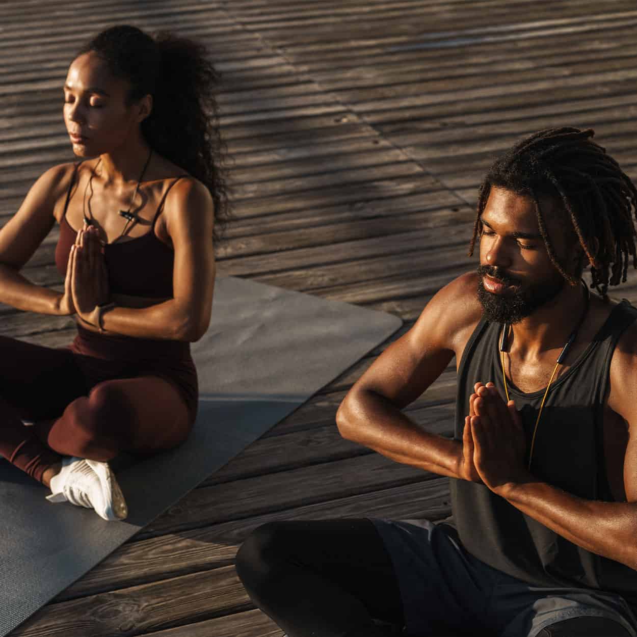 man and woman doing mindful yoga during at-home addiction treatment