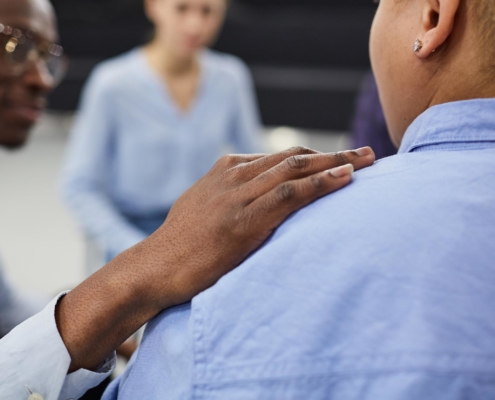 Image of a sober coach comforting another person.