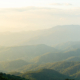 serene landscape showcasing rolling mountains under soft, hazy sky