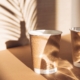 Two paper cups on sunlit background with shadows