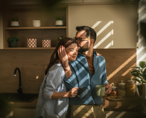 Loving couple sharing intimate morning moment in kitchen