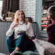 Stylish professional therapist holding pen while listening to client